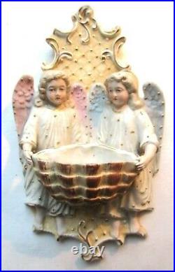Ancien bénitier en porcelaine biscuit 2 anges portant un gros coquillage