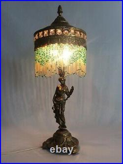 Ancienne lampe orientaliste en laiton à deux feux, femme drapée. Perles en verre